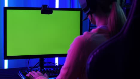 woman gamer playing games with neon lights background. green screen back ground into desktop monitor.