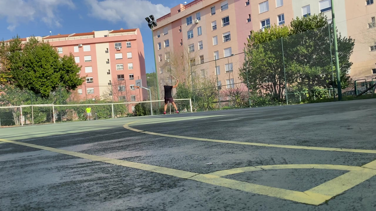 Dwie osoby grają w tenisa w ciągu dnia w parku tenisowym na osiedlu mieszkaniowym, ujęcie w zwolnionym tempie koncepcji aktywności rekreacyjnych i wolnego czasu