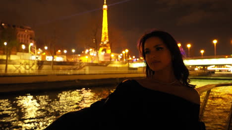 mujer hermosa en un paseo en barco turístico por el río sena en parís, francia, por la noche