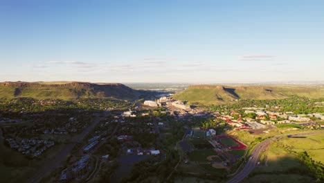 drone establishing shot of small denver city limits suburban town golden colorado during warm golden sunset