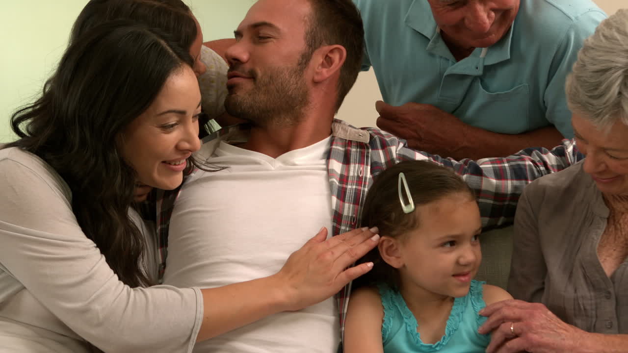 familia de varias generaciones sentadas juntos en el sofá