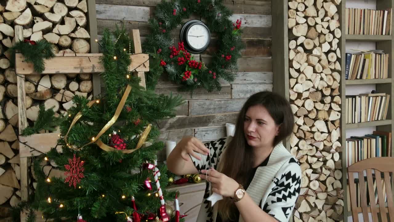 mujer decorando árbol de navidad y chimenea