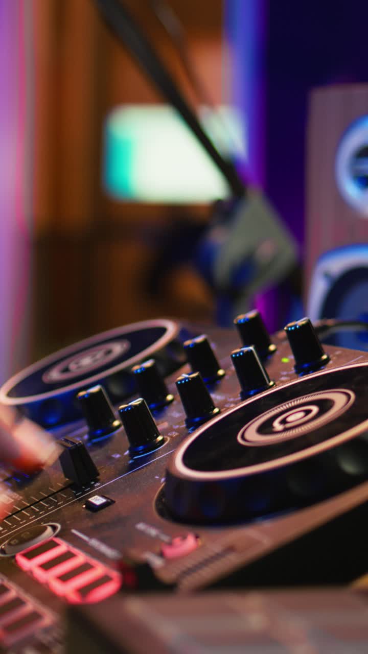 Hænder betjener DJ-mixer og MIDI-keyboard i musikstudie