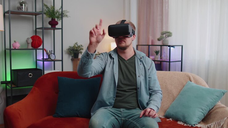 Uomo adulto usa un visore per la realtà virtuale a casa giocando a un videogioco 3D gesticolando con le mani