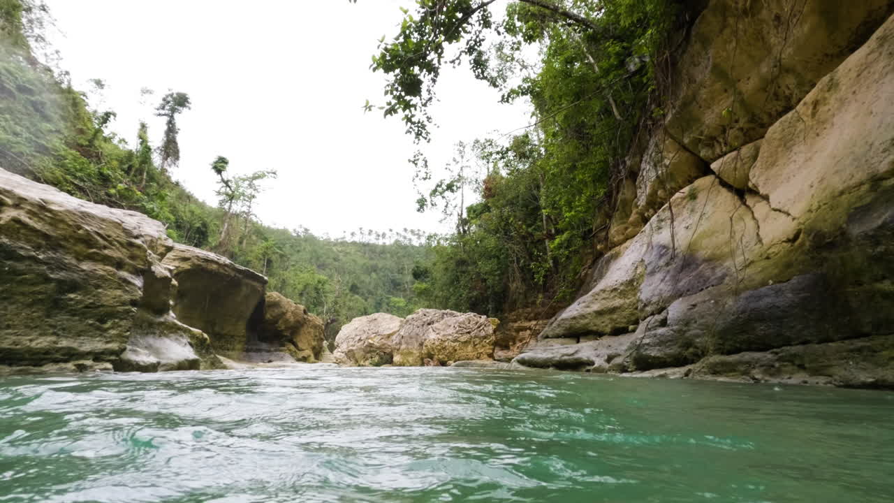 flotando río abajo en el río antes de bucear por debajo de la superficie al final del clip - cámara lenta y clima lluvioso en el desierto de filipinas
