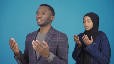 african muslim woman and man in hijab pray, they believe in allah, they have faith.