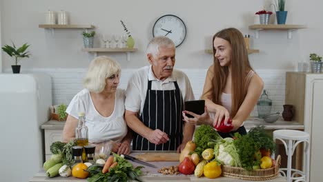 senior man and woman listening recipe from girl with digital tablet of healthy food nutrition