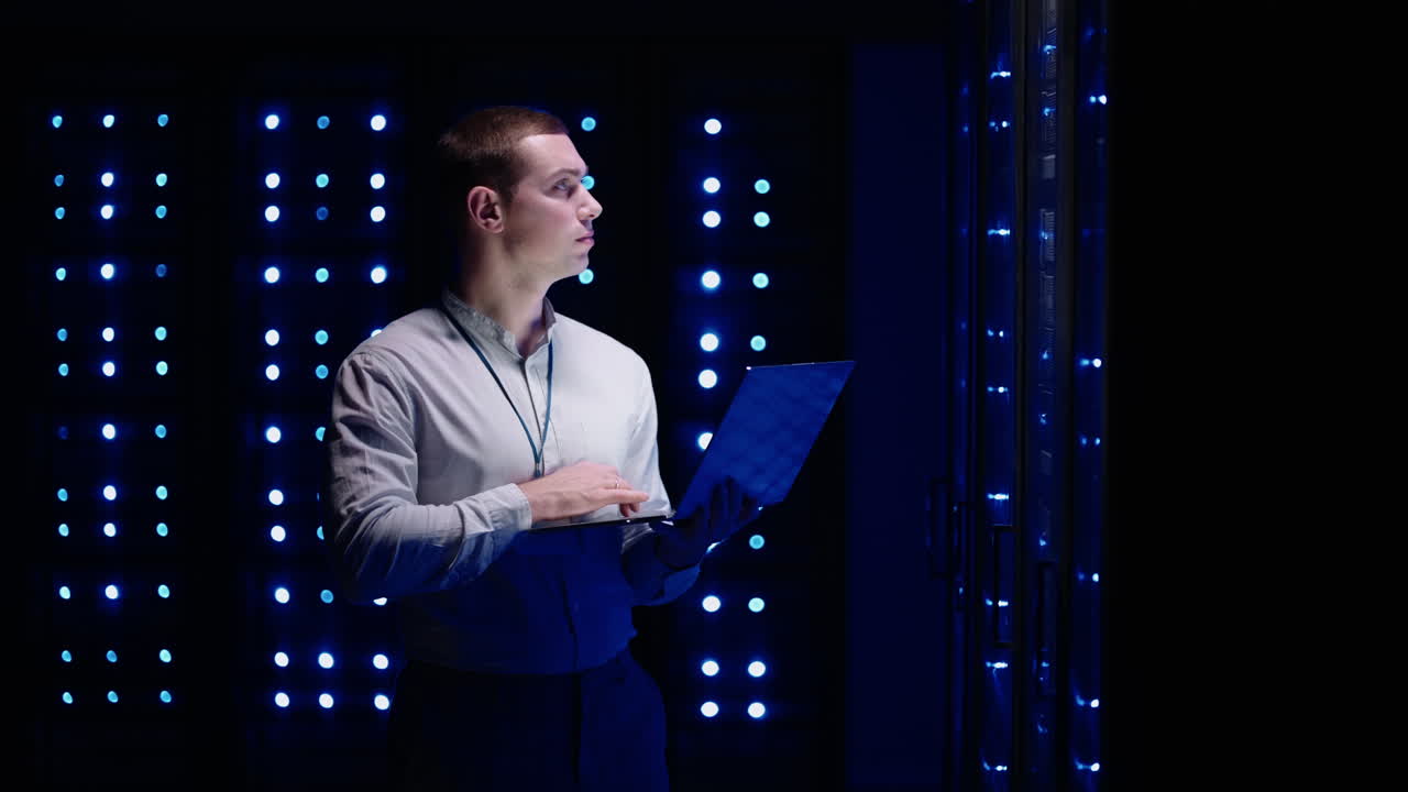 el concepto de digitalización de la información: es un especialista de pie frente a los racks de servidores con portátil que activa el centro de datos con un gesto táctil. datos de red