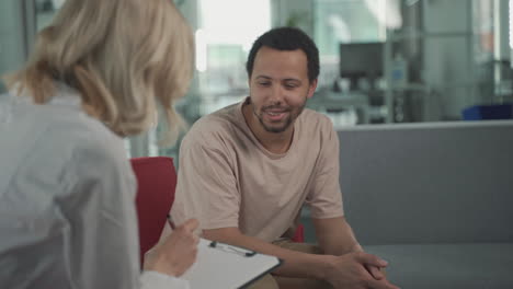 a young black man answers questions from a female doctor