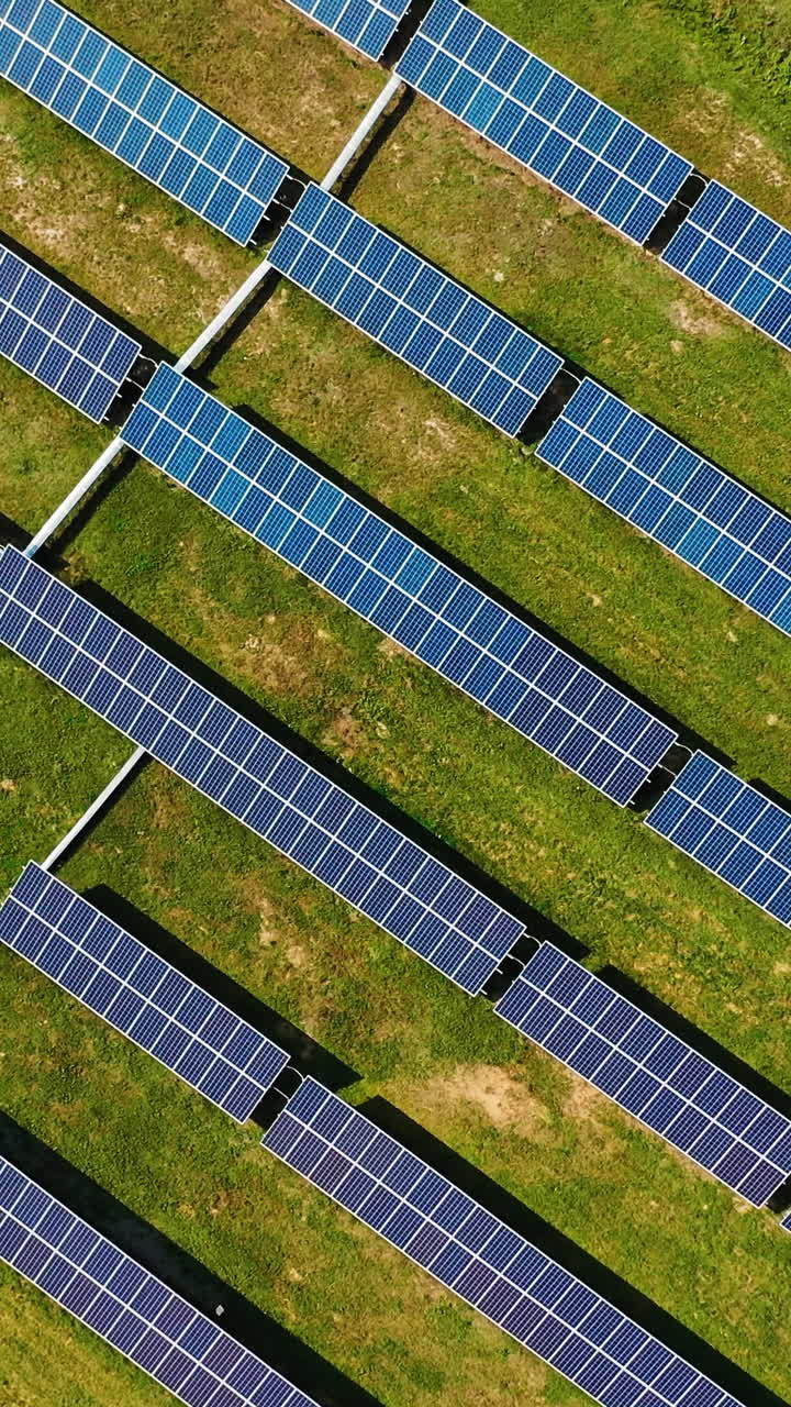 Aerial top view of solar power plant. Alternative clean electricity. Drone view of solar panels in the field. Motion up down. Vertical video