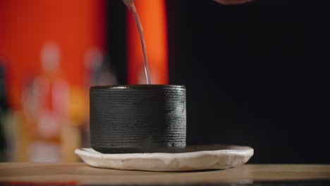 bartender pouring cocktail into cup