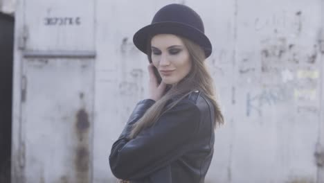 stylish woman in a black hat and leather jacket