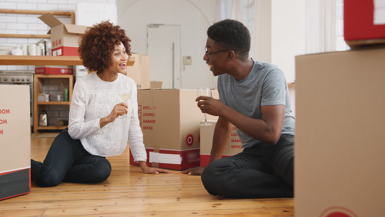Couple Celebrating Moving Into New Home Making A Toast With Wine