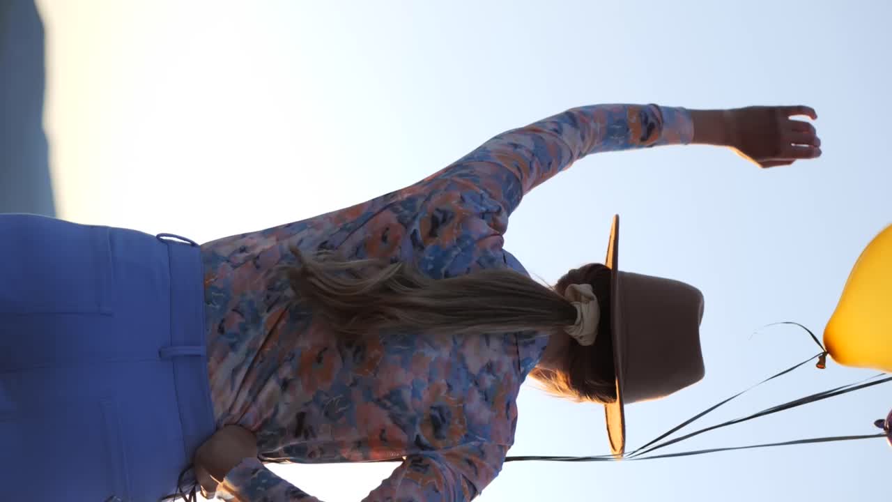 호수 근처 에 풍선 을 가지고 춤추는 긍정적 인 여자