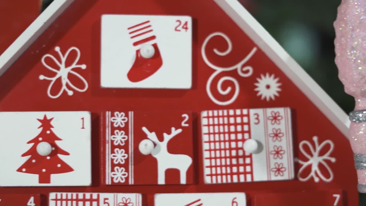 calendario de adviento de árbol de madera frente a un árbol de navidad real decorado juguetes de soldado cascanueces