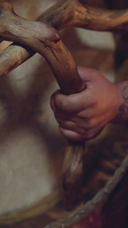 man supports shamanic traditions and plays ritual drum at performance on stage closeup. musician plays tribal instruments. folk band show