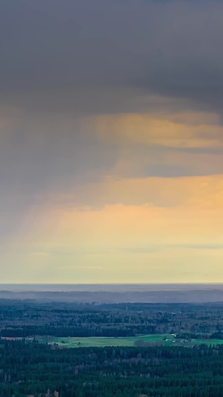 Dark rain clouds swiftly move across the landscape in a dramatic time-lapse scene