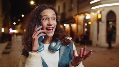 young woman talking on phone at night