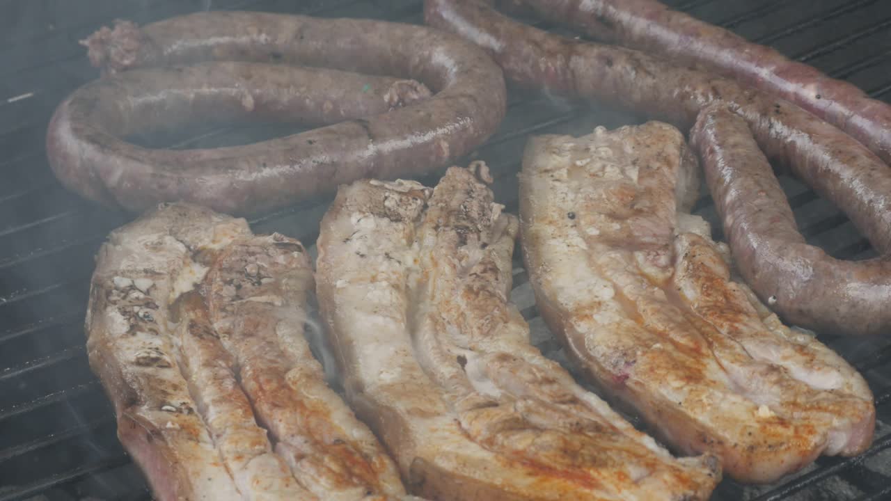 Boerewors und Schweinefleisch auf einem Außengrill in Südafrika, Nahaufnahme.