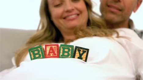 happy pregnant woman with baby cubes on belly