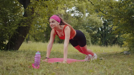 Chica-Atlética-Y-Deportiva-Haciendo-Ejercicio-En-El-Parque-Sobre-Una-Alfombra-Deportiva-Realizando-Entrenamiento-De-Yoga,-Pose-De-Tabla