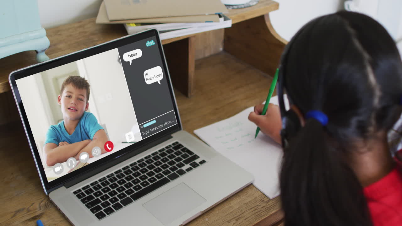 chica afroamericana haciendo la tarea y teniendo una videollamada con un compañero de clase en una computadora portátil en casa