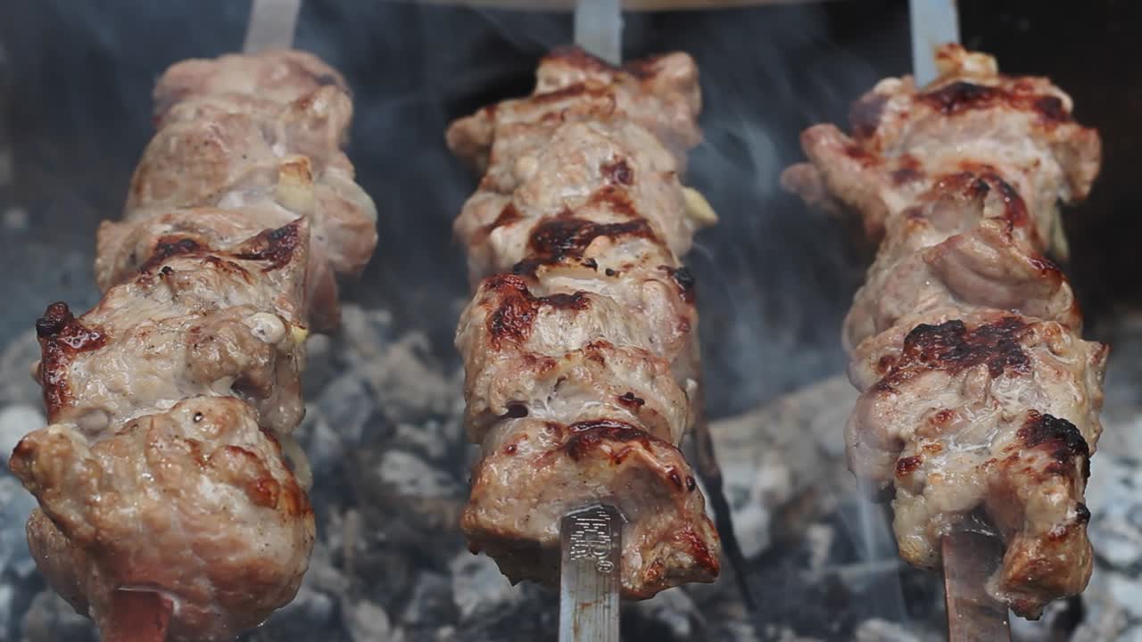 pinchos de carne de barbacoa a la parrilla en un picnic. cerrar el shish kebab en la parrilla de carbón