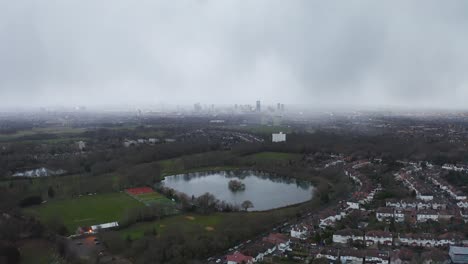 Enfoque-Aéreo-De-Londres-Con-Lago-Debajo,-Brumoso-Y-Malhumorado