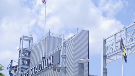 exterior views of acrisure stadium, featuring trees and the american flag