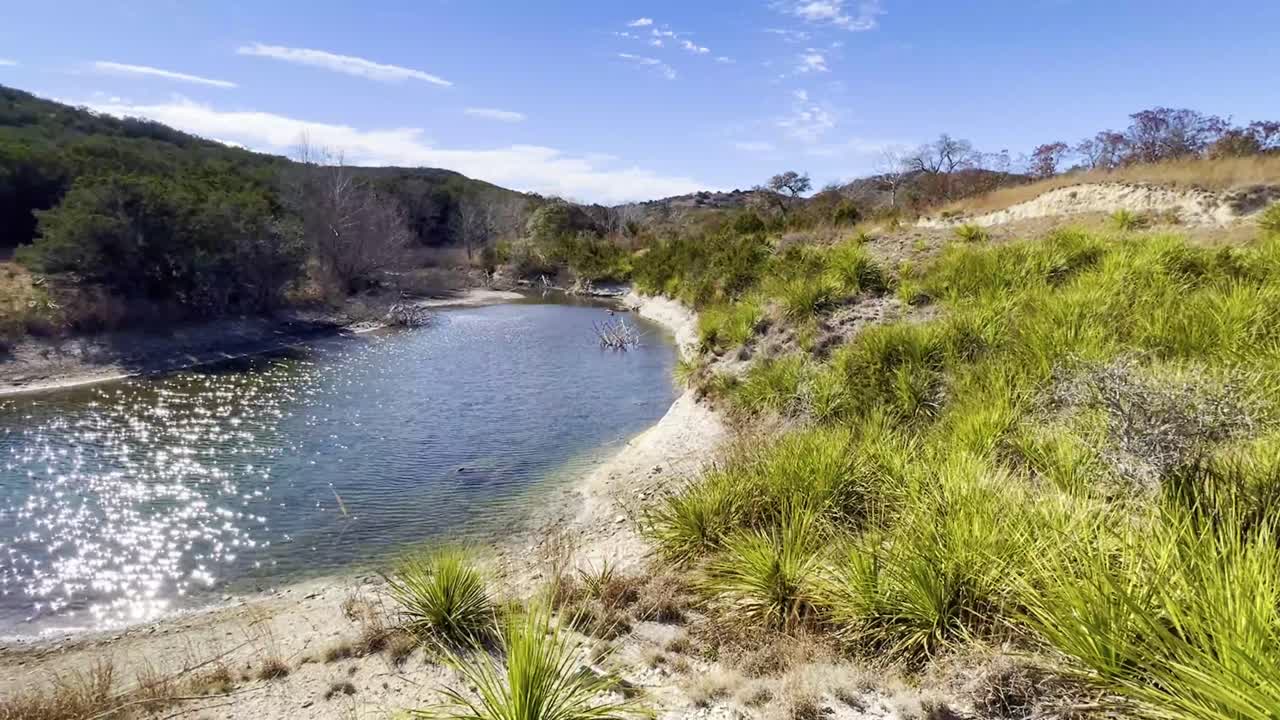una hermosa escena natural soleada de un lago oasis y vegetación en la región montañosa de texas
