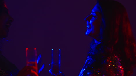 cerca de dos mujeres en un bar de club nocturno o discoteca bailando y bebiendo alcohol 3