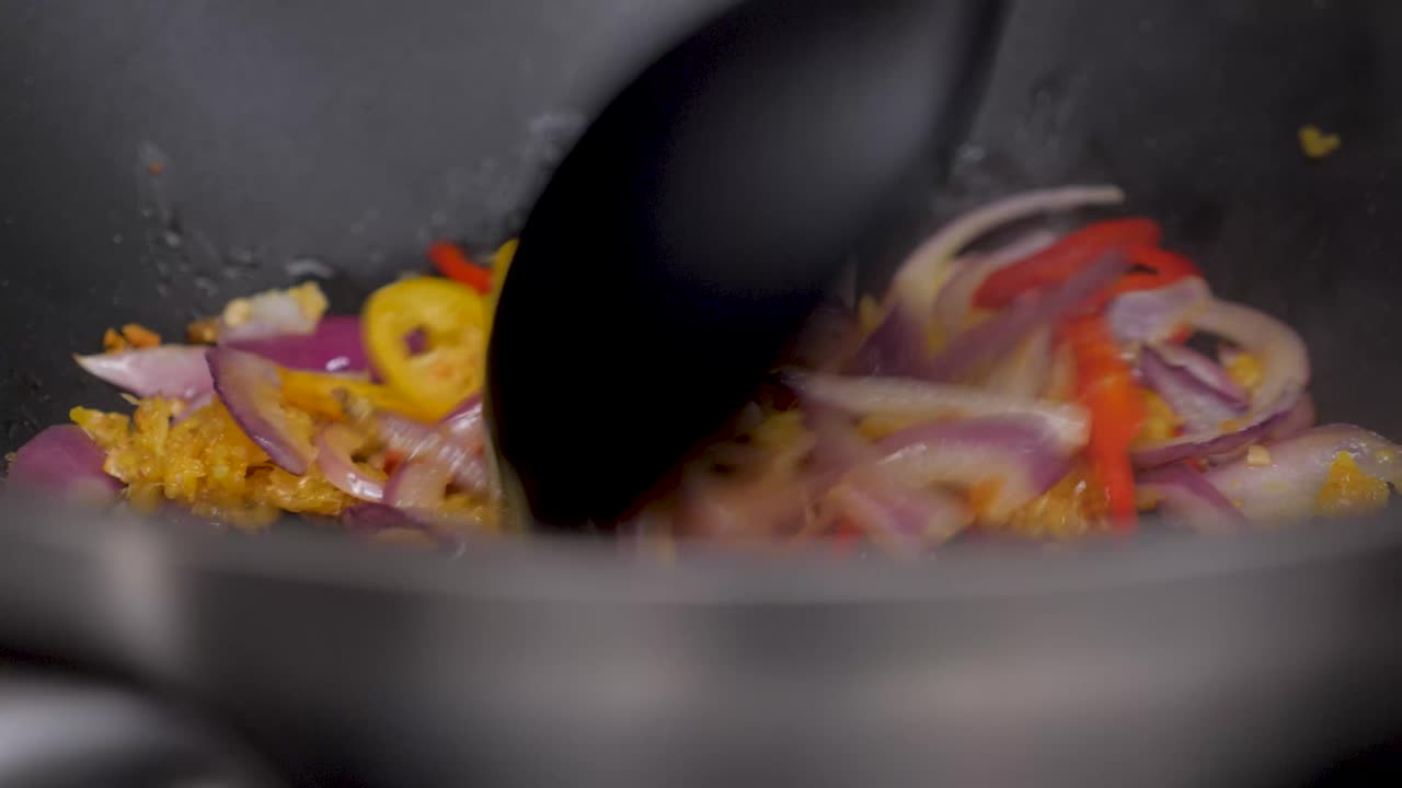 el chef saltea las cebollas, el ajo y el jengibre para darle sabor, un primer plano estático