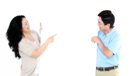 mature couple holding and pointing a white board