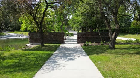 park gate during a beautiful summer day surrounded by lush greenery, grass, and trees under a clear blue sky