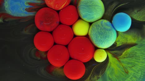 colorful bubbles. abstract red, yellow, blue, green mixture on a black background. artistic color paint background.