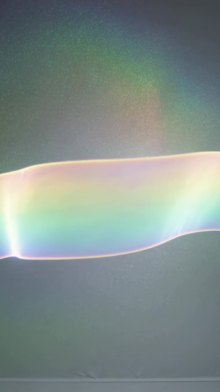 Vertical video: Soap film entering left, drifting over painted wall, revealing color for design