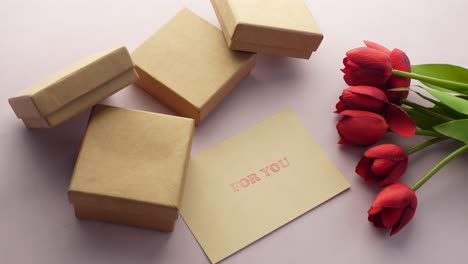 top view of gift box, envelope and tulip flower on  background