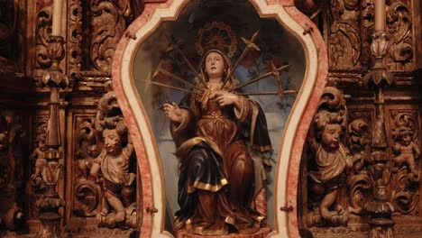 baroque our lady of sorrows statue with swords in an ornate altar