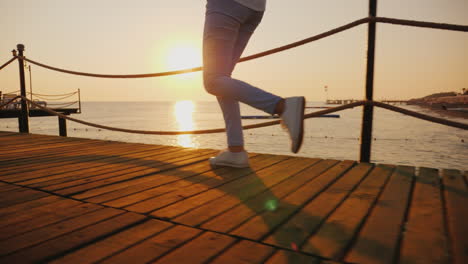 morning jog on the pier when the sun rises over the sea in the frame only the legs are visible stead