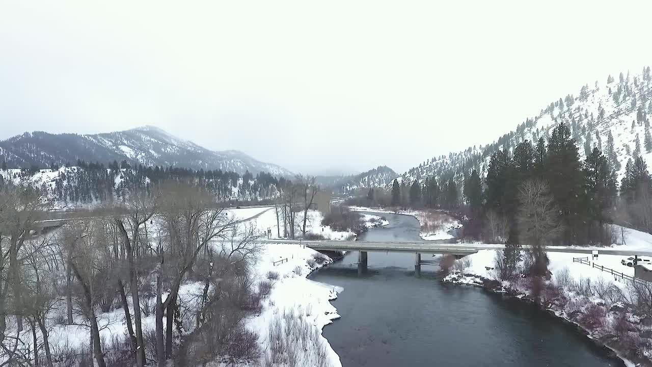 공중 - 드론이 강 위의 다리를 향해 날고 있습니다.