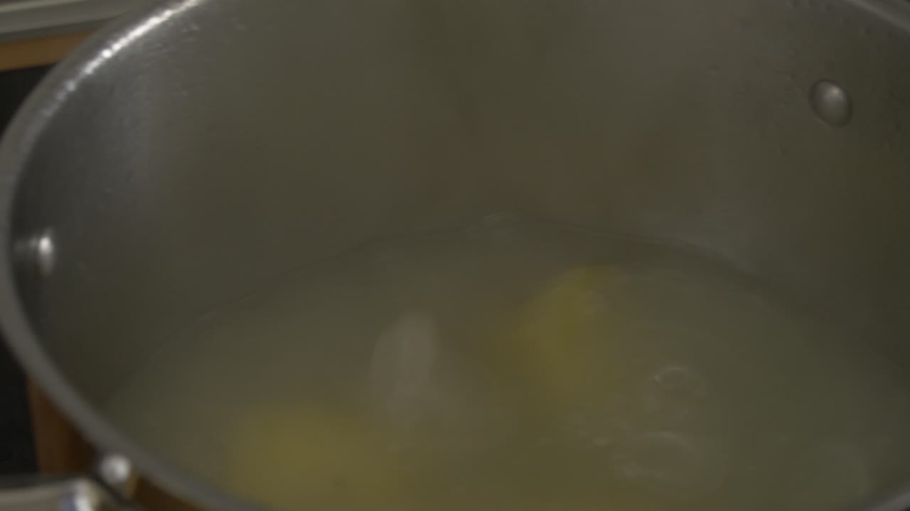 abriendo la tapa de una olla de patatas hirviendo
