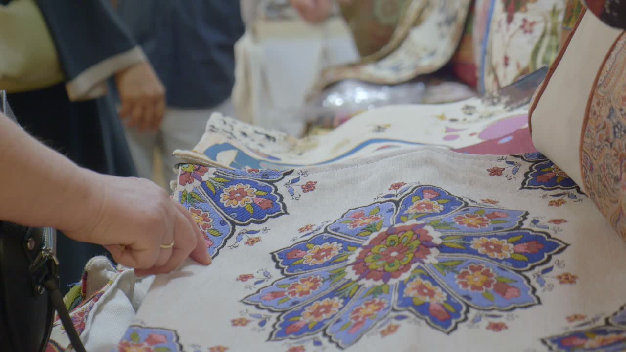 Close-up of Hand Pointing at Floral Patterned Textile