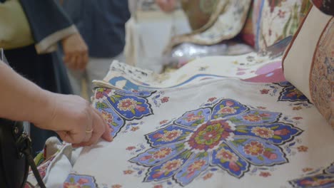 close-up of hand pointing at floral patterned textile