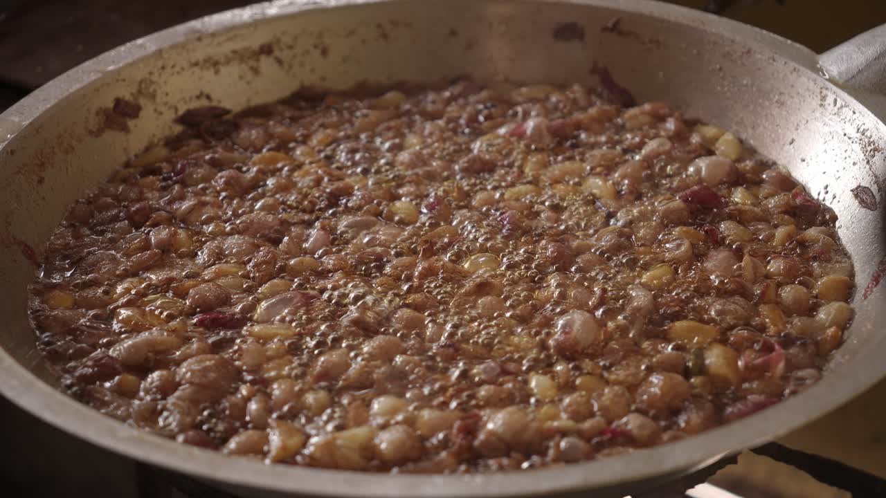 Crispy garlic and shallots frying in oil, sizzling and bubbling in a pan