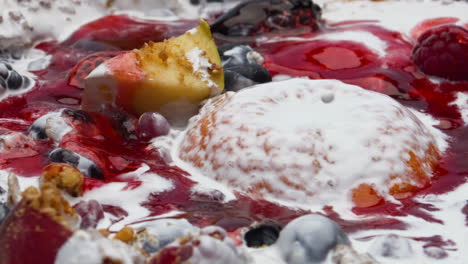 jam pouring fruits muesli dipped into fresh yogurt closeup. nutrient porridge.