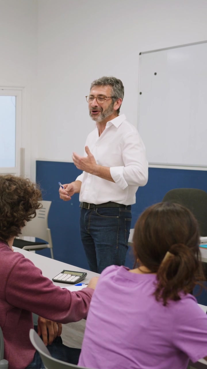 Insegnante sorridente che spiega la lezione agli studenti in classe