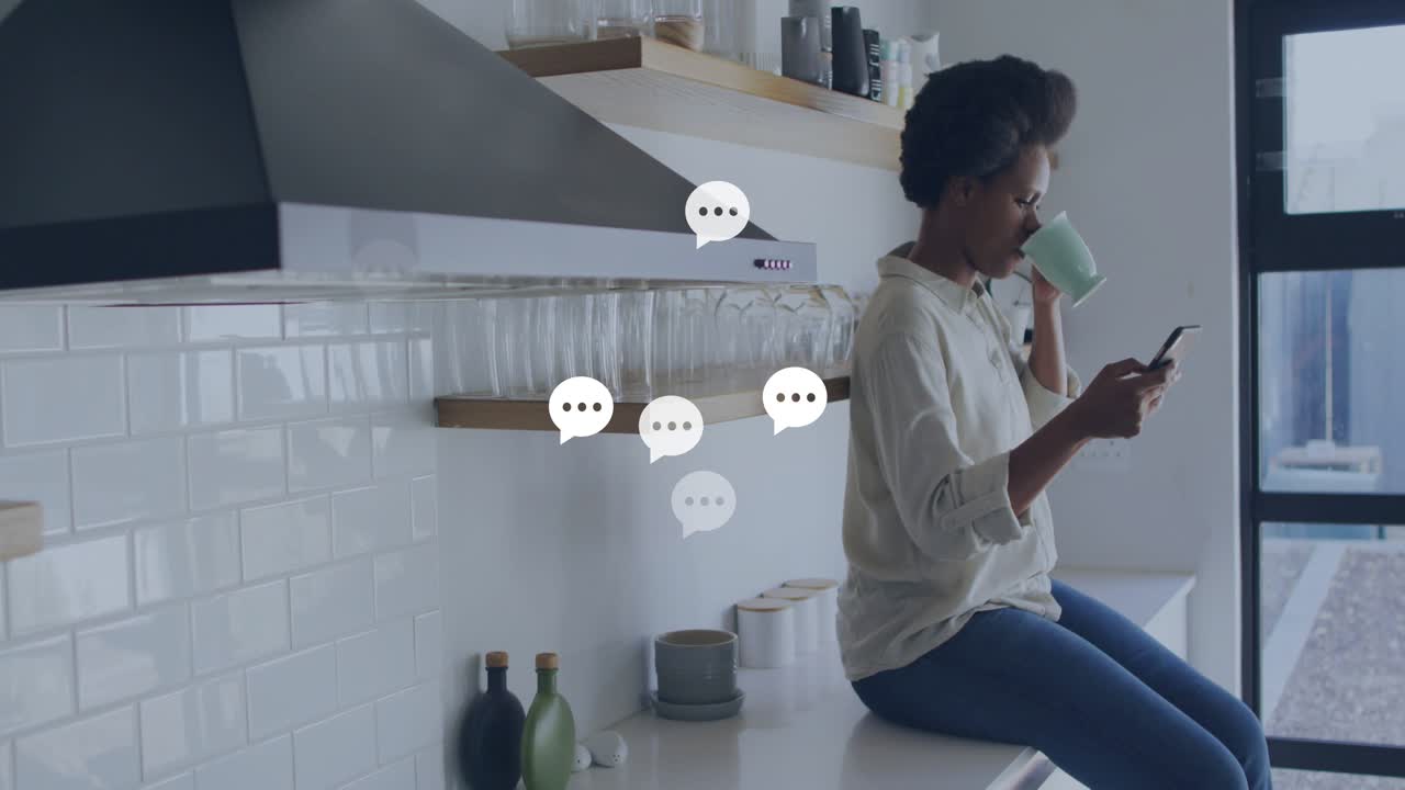 Kvinde ved køkkenbordet nipper til en kop og tapper på telefonen, hvilket starter chatbobler, der viser meddelelsesflow.