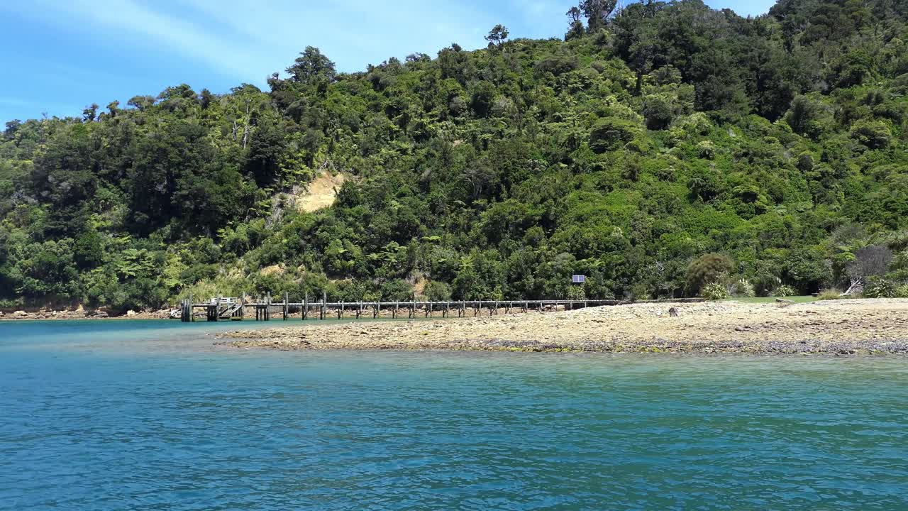 hermoso mar azul profundo que cambia a turquesa con exuberante vegetación y embarcadero en la cala del barco