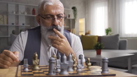 mature man playing chess and developing his strategies.