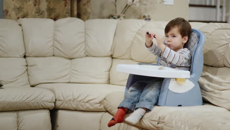 A-cool-little-boy-eats-dumplings-on-his-own.-Sits-in-a-high-chair